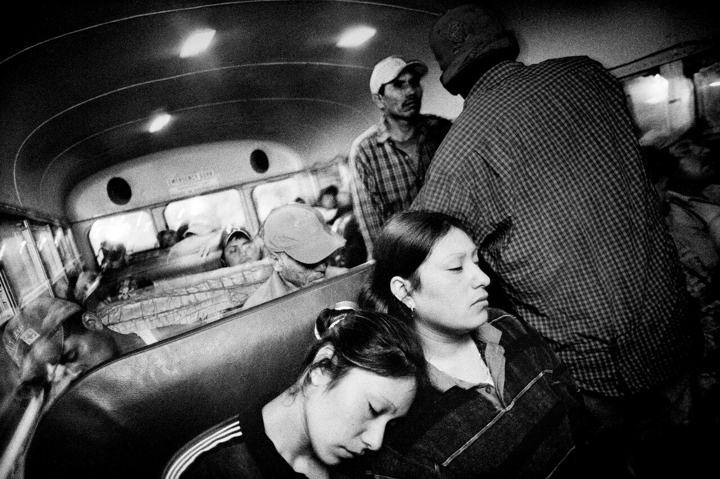Black and white photo of people in a bus by Matt Black