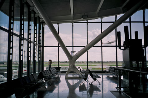 Interior of an airport with large windows looking out onto the tarmac