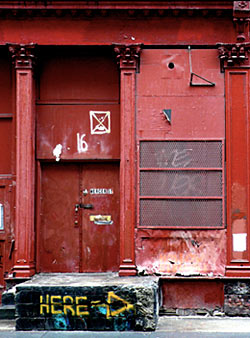 Photograph of red building with street art and graffiti