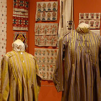 Textiles from "From Tent to Palace" exhibit showing clothing and wall hangings