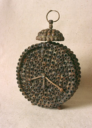 a clock made of seed pods and bee's wax 