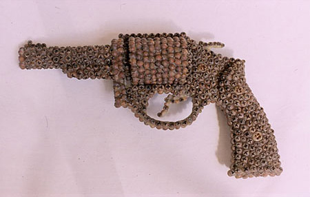 Sculpture of a handgun made out of seed pods and bee's wax 