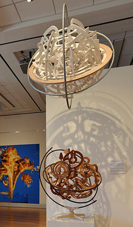 Large wire spheres filled with complex forms.  One is hanging the other is stationary  