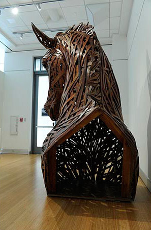 The back view of large brown horse head and torso created from cardboard and wood 