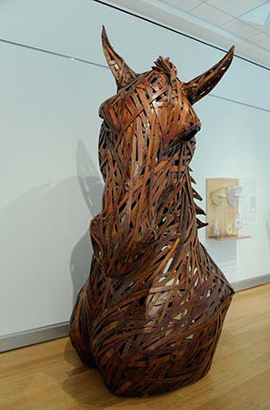 Front view of large brown horse head and torso created from cardboard and wood 