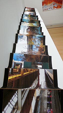 Long fan folded photograph of street art neighborhoods mounted on black background 