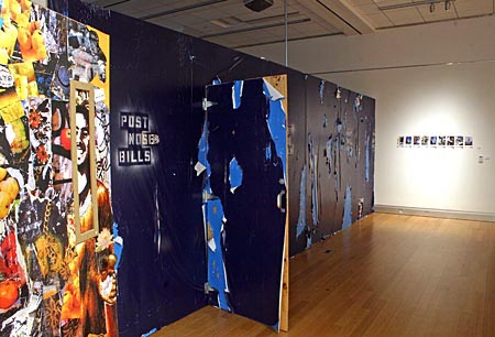 Gallery view of installation of a long blue wall with with graffiti