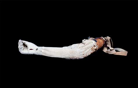 Disembodied arm wrapped in gauze like fabric by Catherine Wagner