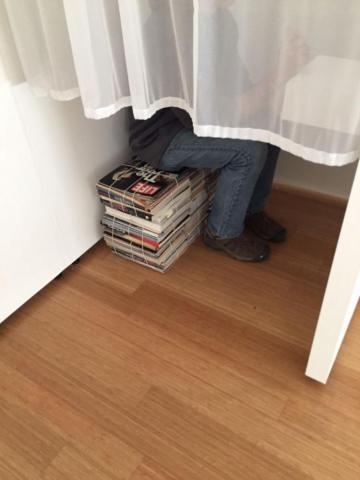 Photograph of a person sitting on magazines by Renata Breth